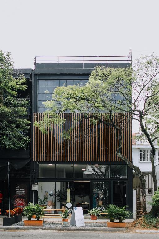 un edificio negro con un árbol delante de él en Soy Local Provenza, en Medellín