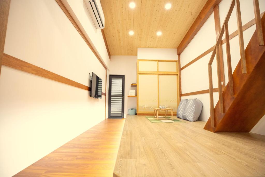 um quarto com um corredor com uma porta e pisos em madeira em Lost Circle Homestay em Tainan