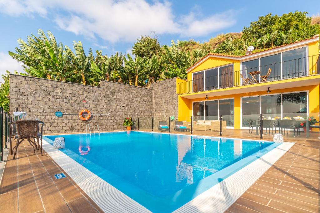 a swimming pool in the backyard of a house at Zeza´s house in Calheta