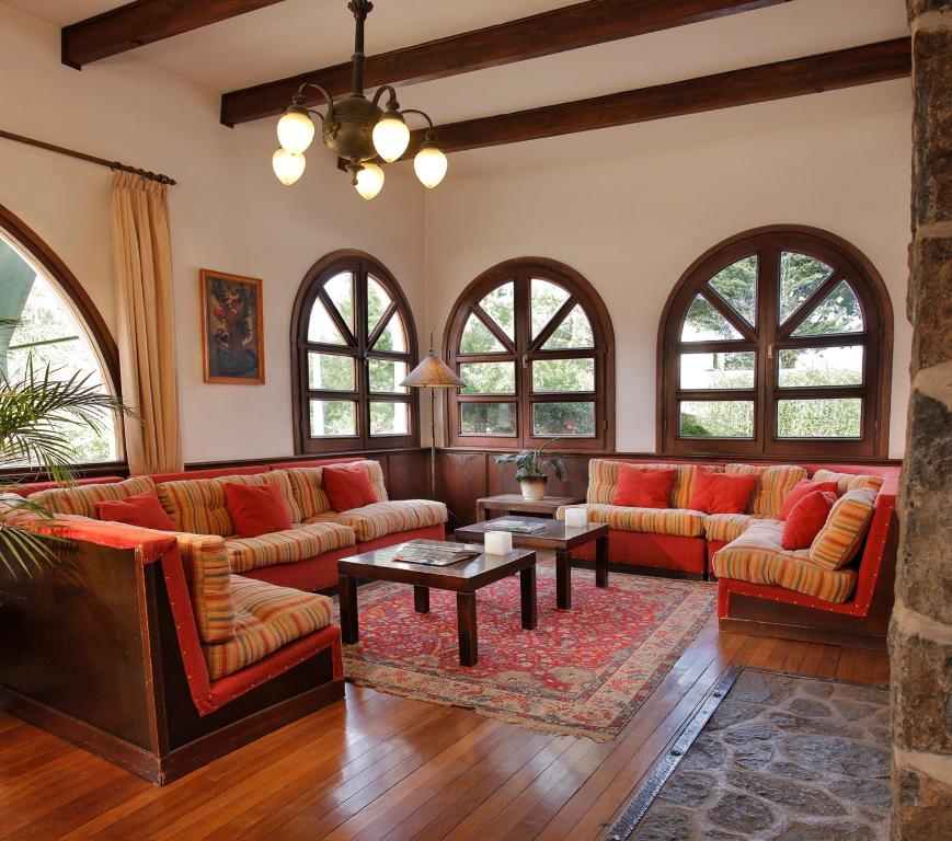 a living room with red couches and a table at Bremen Hotel & Spa in Villa General Belgrano