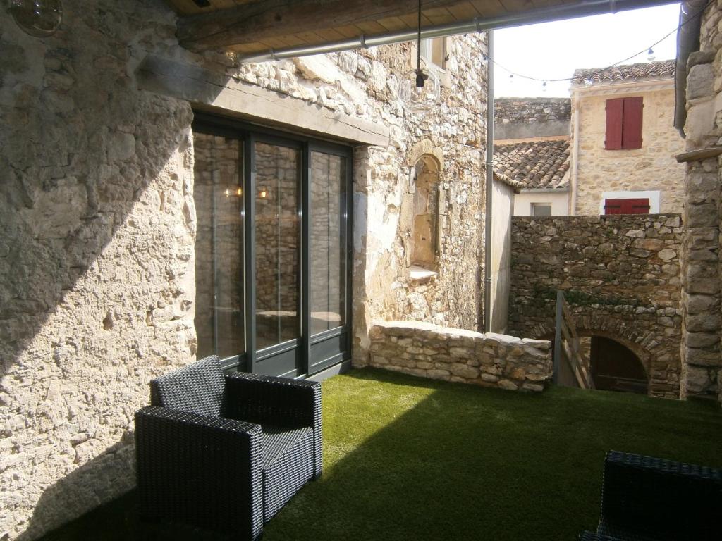 an outdoor patio with two chairs and grass at Le gite d'à côté in Fons-outre-Gardon