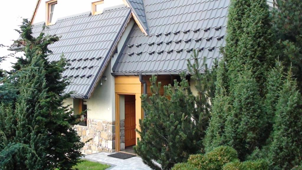 a house with a metal roof and some trees at Willa Natura in Gliczarów