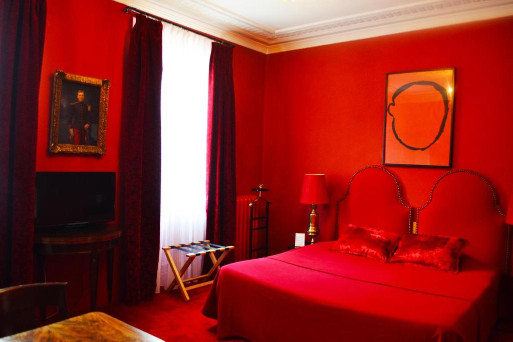 a red bedroom with a bed with a red bedspread at Hotel Windsor Home in Paris