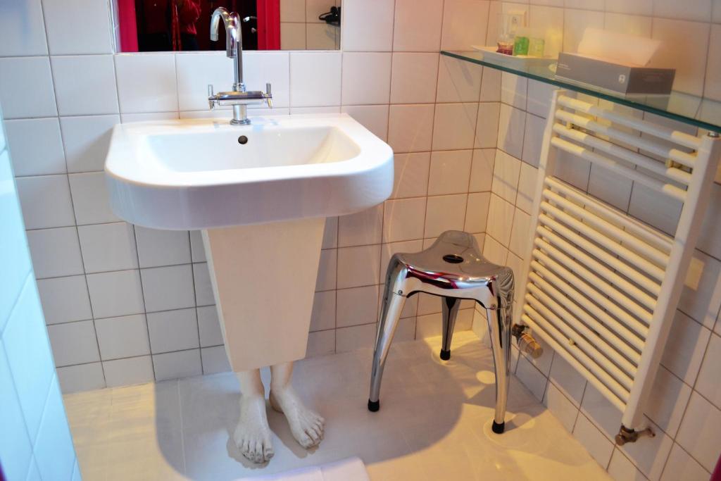 a white sink in a bathroom with a stool at Hotel Windsor Home in Paris