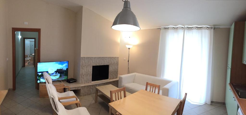 a living room with a television and a table and chairs at Appartamento a pochi passi dal mare con Wi-Fi Gratuito in Santa Caterina dello Ionio
