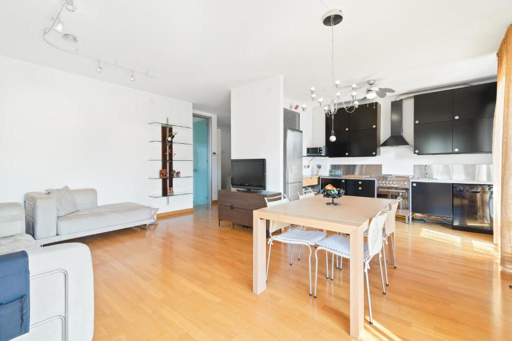 a kitchen and living room with a table and chairs at Padova Terrace Flat in Padova