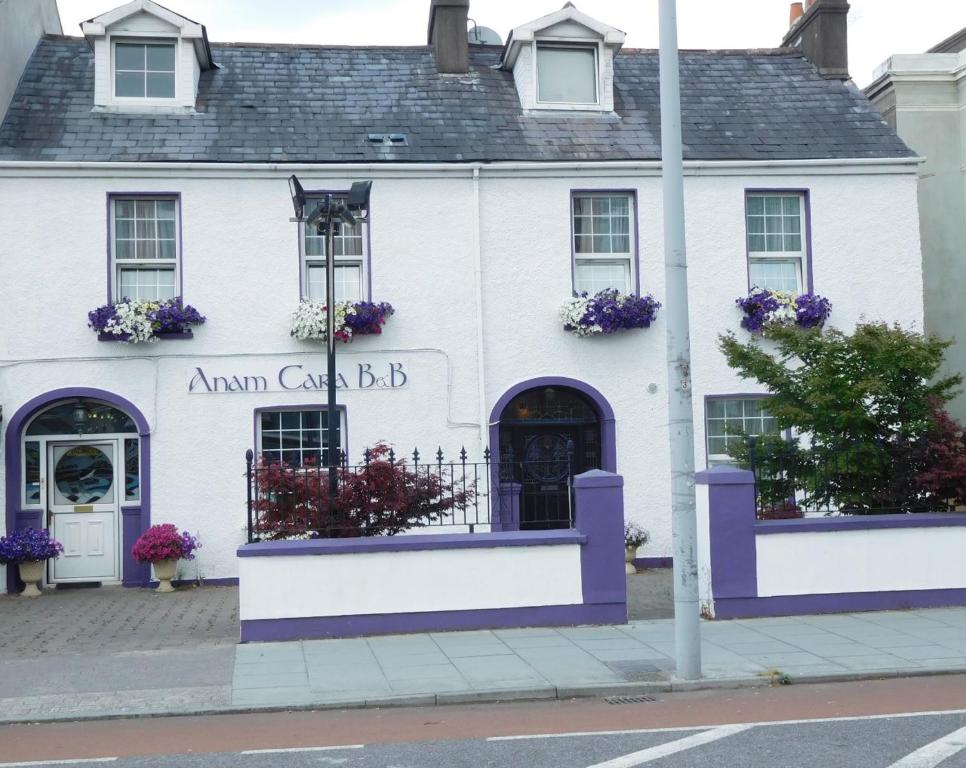un edificio blanco con flores púrpuras en la parte delantera en Anam Cara B&B, en Cork