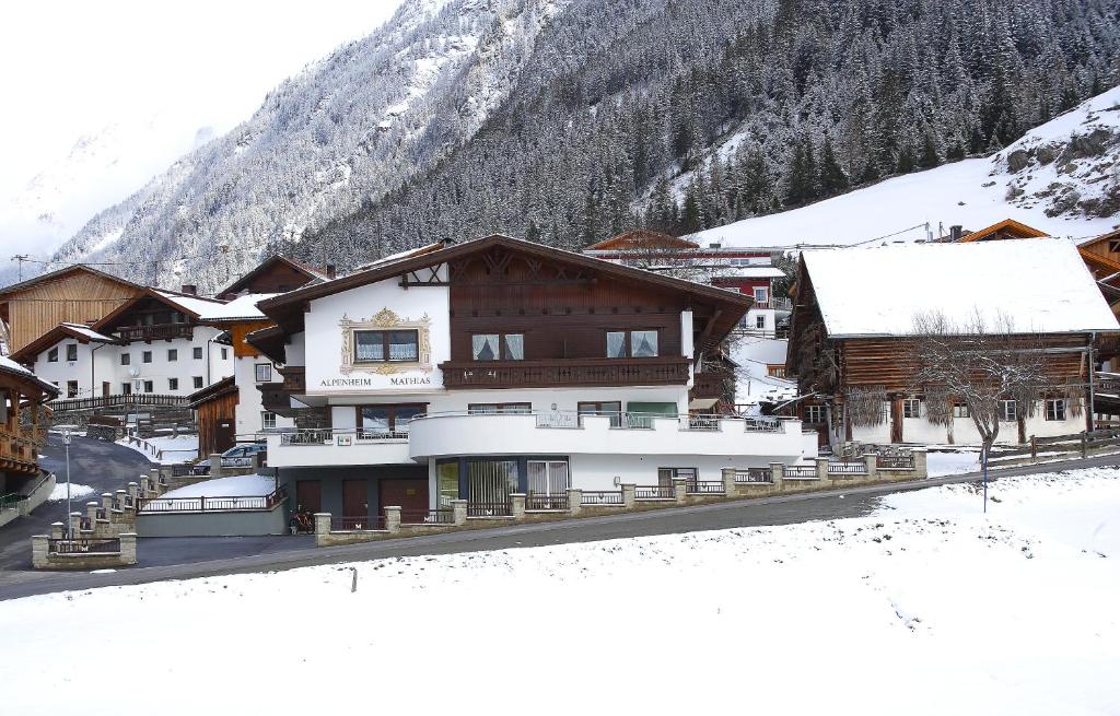 a snow covered town with buildings and a mountain at Alpenheim Mathias in Sölden