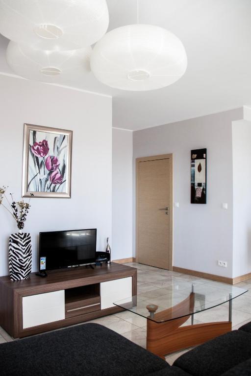 Televízia a/alebo spoločenská miestnosť v ubytovaní Senator Warsaw Apartments