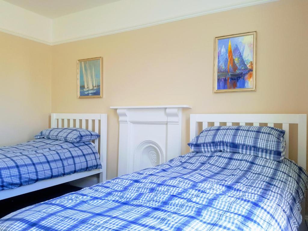 een slaapkamer met 2 bedden en een open haard bij Big, Beautiful, Cosy Falmouth House in Falmouth