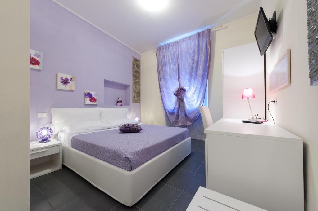 a white bedroom with a bed and a blue curtain at Affittacamere Dune Blu in Riomaggiore