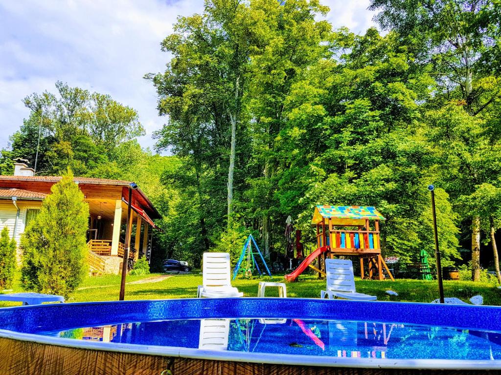 una piscina con sillas y un parque infantil en Hotel Valdis, en Pastra