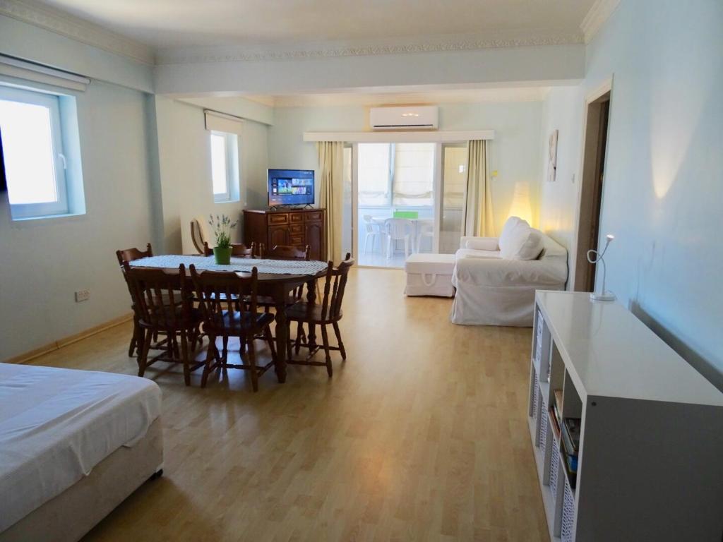 a living room with a table and chairs and a couch at Camilla City apartment in Larnaca