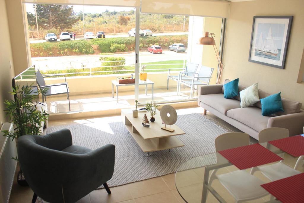 a living room with a couch and a table at Laguna Bahia Algarrobo in Algarrobo