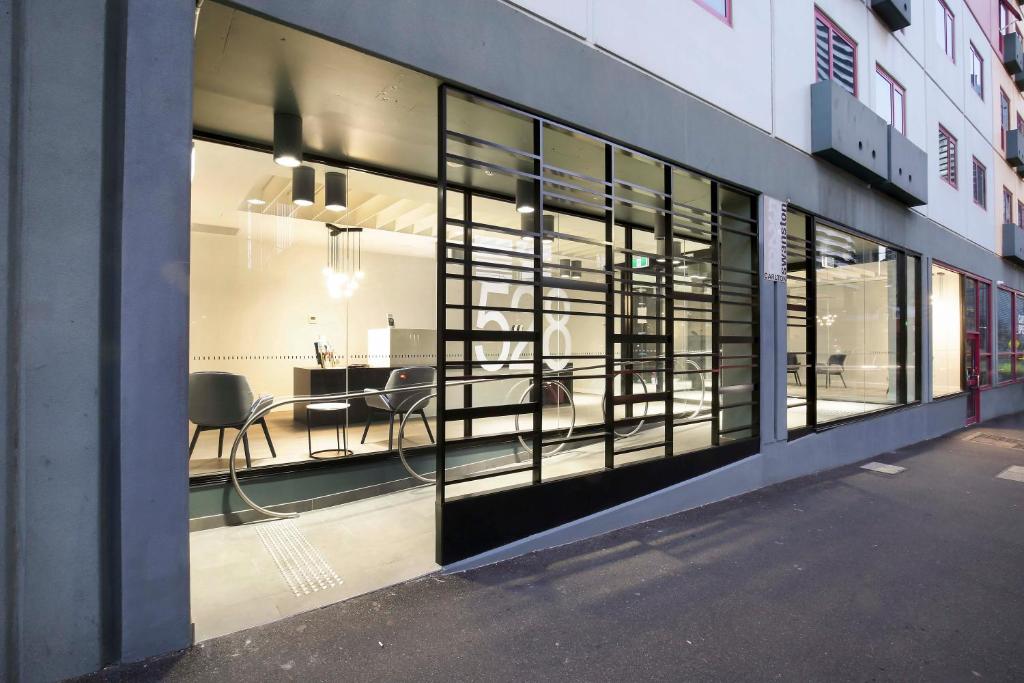 a large window of a building with chairs in it at Plum Serviced Apartments Carlton in Melbourne