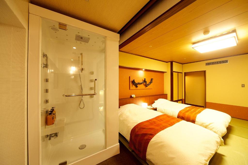 a bathroom with a bed and a shower in a room at Tosagyoen in Kochi