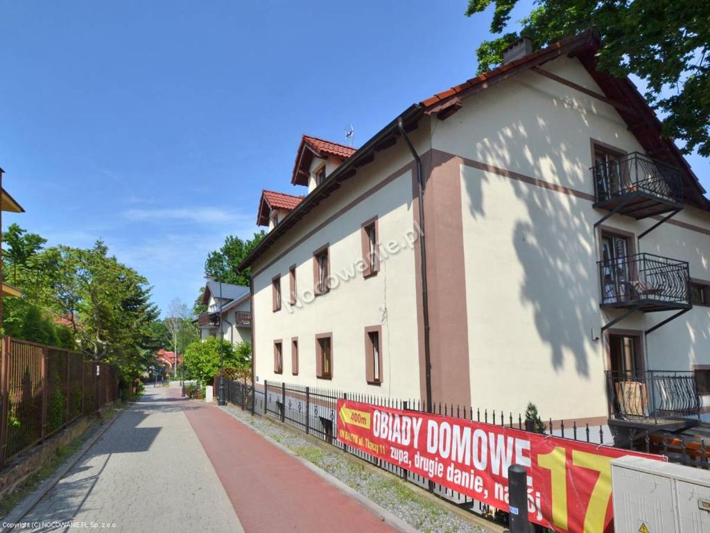 un edificio blanco con una valla al lado de una calle en Pod Dębem en Krynica Morska