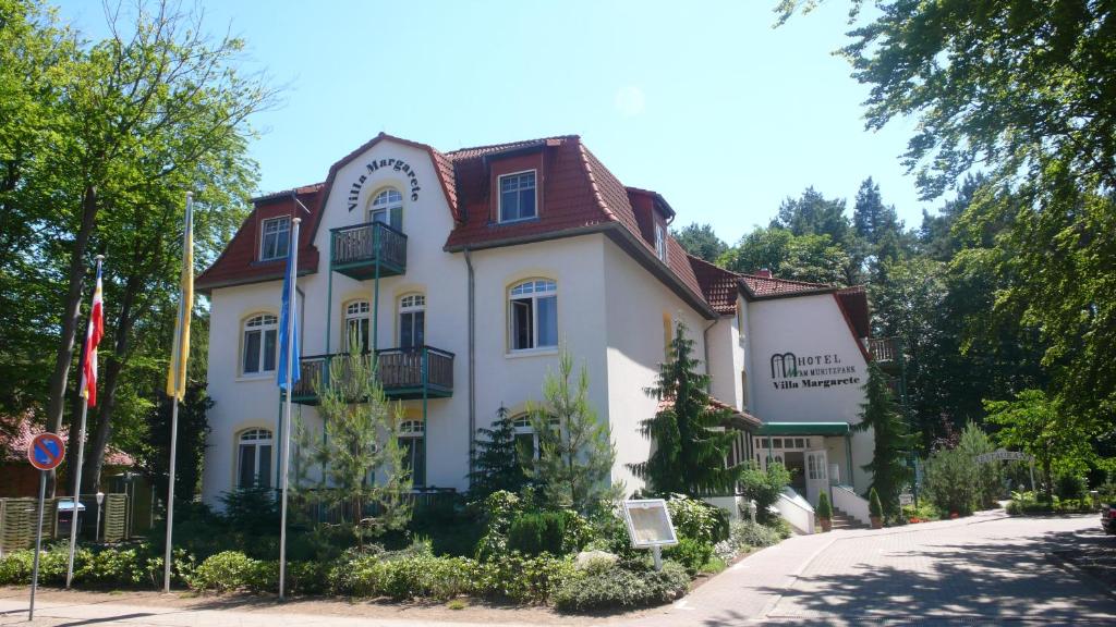 un gran edificio blanco con techo rojo en Ringhotel Villa Margarete, en Waren