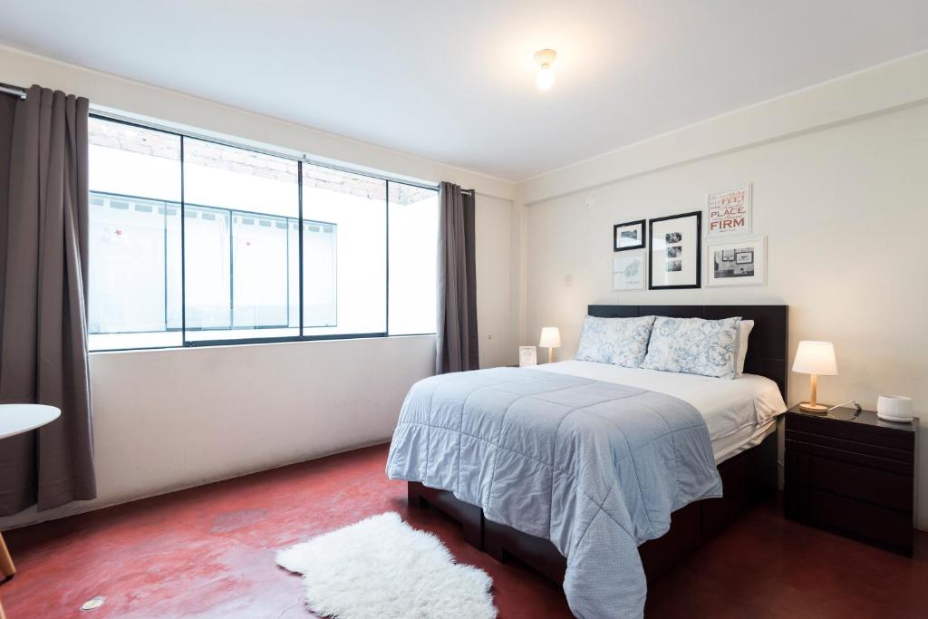 a bedroom with a bed and a large window at InkaHuset Airport in Lima