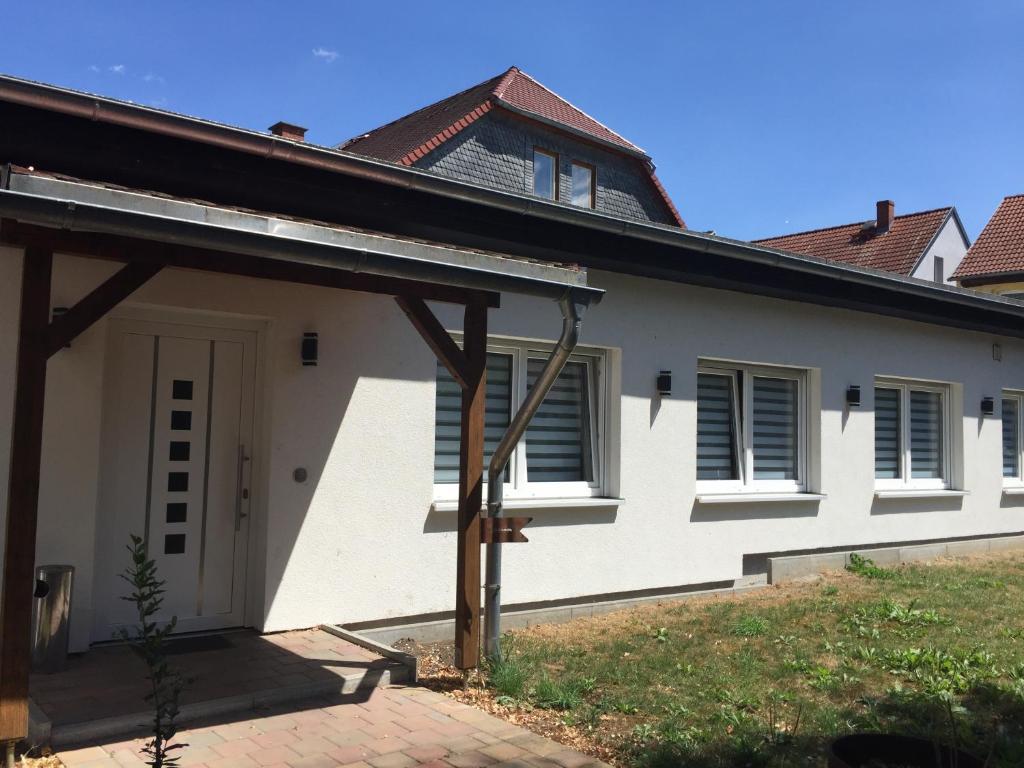 een wit huis met een gambrel dak bij Ferienwohnung „Blaues Schild“ in Dorndorf