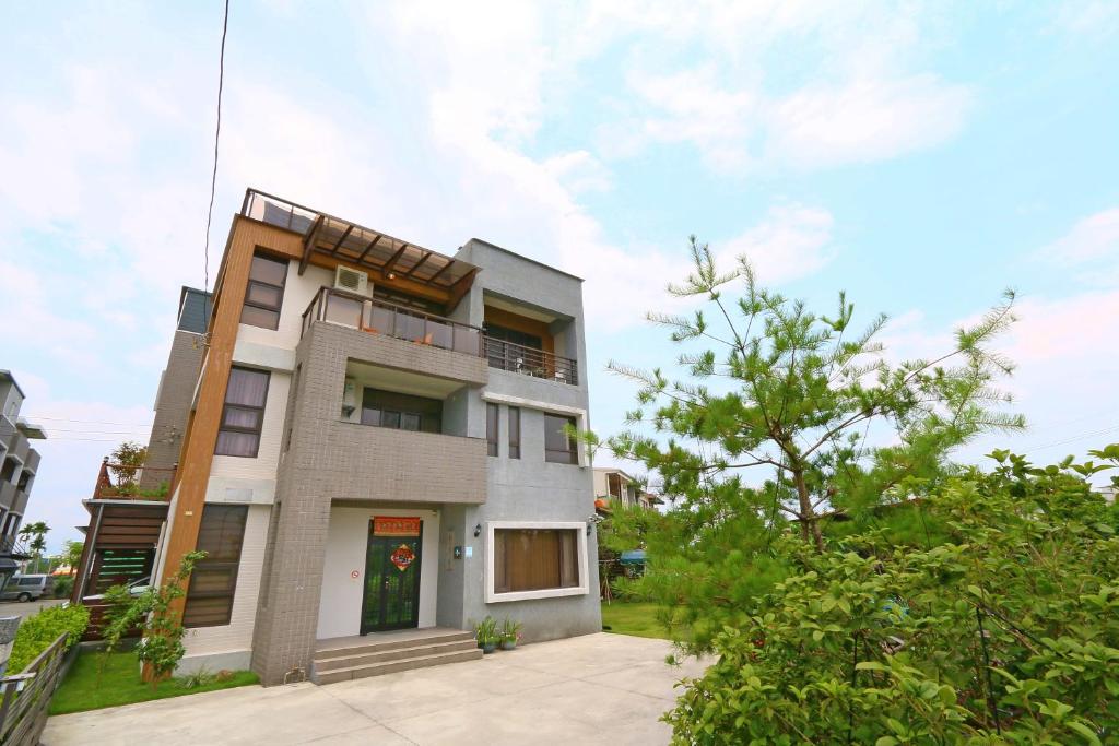 une maison avec un balcon sur le côté de celle-ci dans l'établissement Sakura Love River Bed and Breakfast, à Dongshan