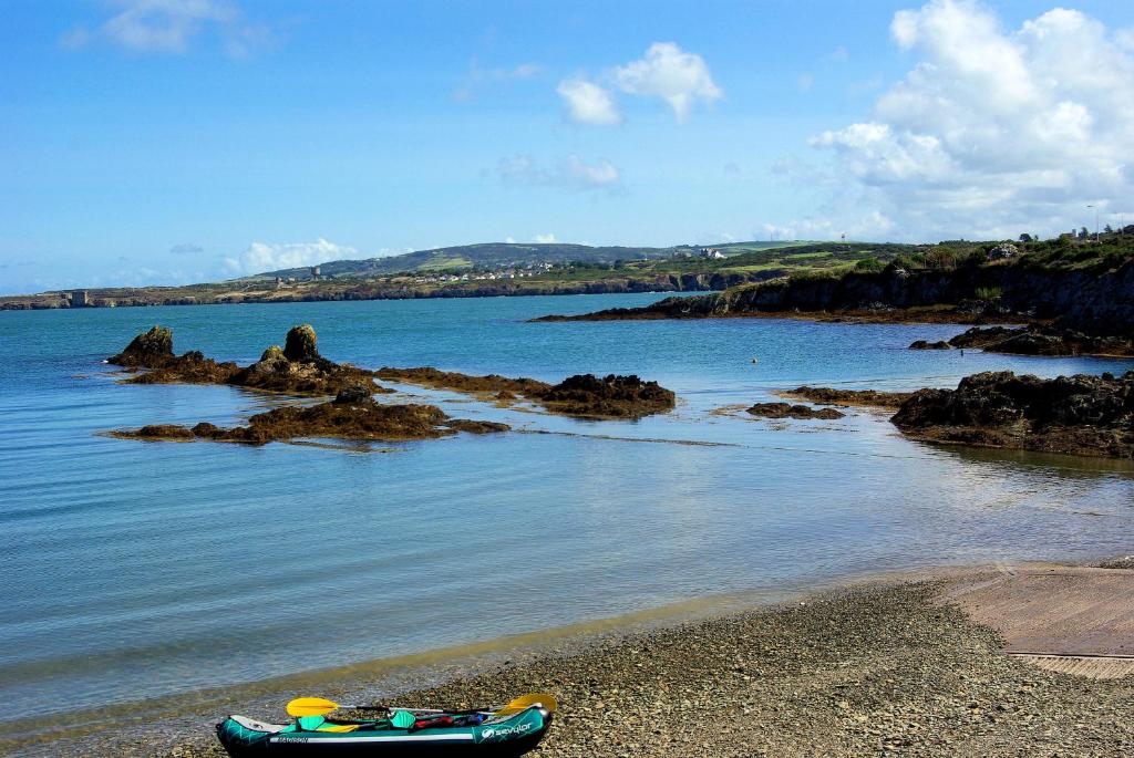 un bateau sur la rive d'une masse d'eau dans l'établissement The Anchorage, à Amlwch