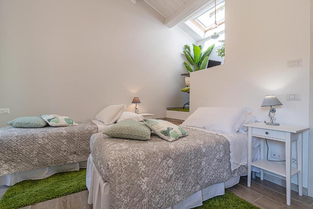 a bedroom with two beds and a table with a lamp at Casa Sferisterio Macerata in Macerata