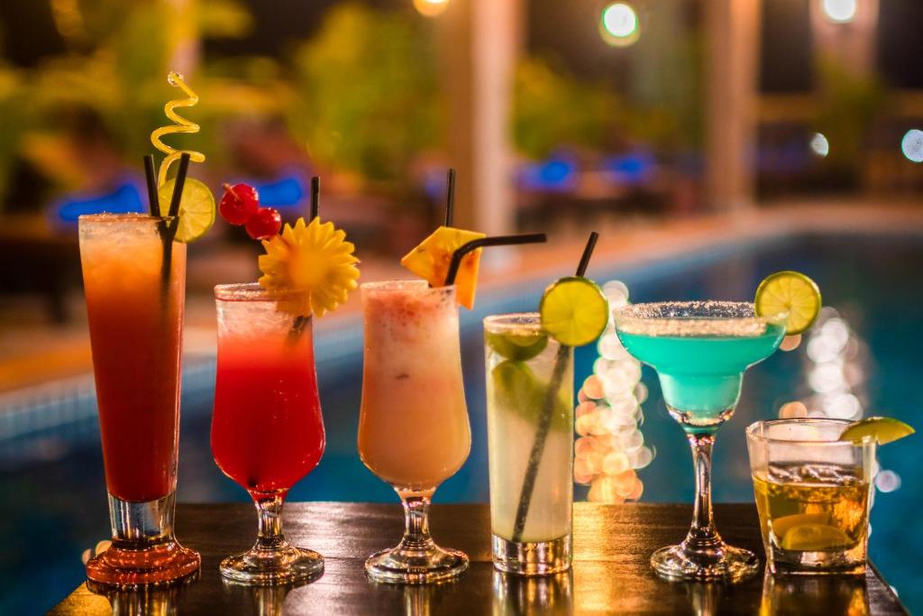 a group of cocktails sitting on a table next to a pool at Okay Boutique Hotel in Phnom Penh