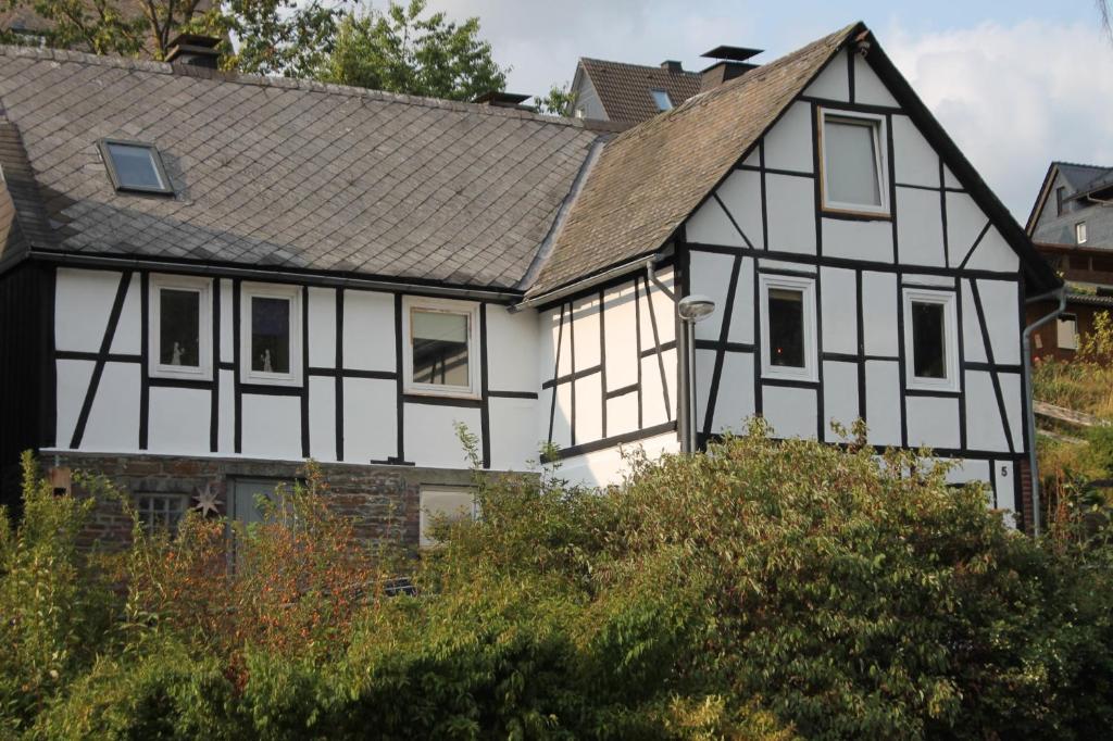 a white and black house with a gray roof at Landhuis Züschen in Winterberg