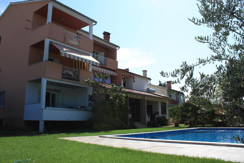 a building with a swimming pool next to a house at AURA Residence in Rovinj