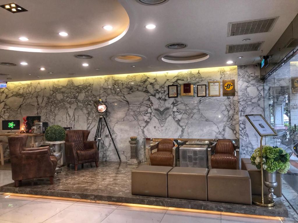 a lobby with chairs and a stone wall at Chao She Hotel in Kaohsiung