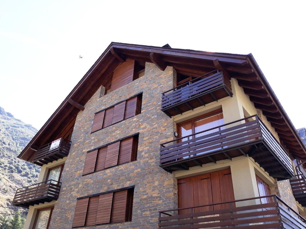 un edificio con puertas y balcones de madera en Dúplex familiar en Esterri d'Àneu, en Esterri d'Àneu