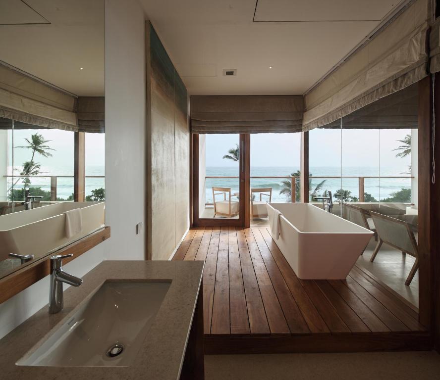 a bathroom with two sinks and a bath tub at Riff Hikkaduwa in Hikkaduwa