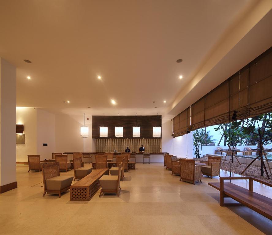 a lobby with chairs and tables in a building at Riff Hikkaduwa in Hikkaduwa