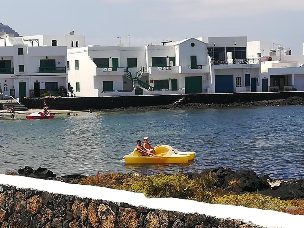 Dos personas montadas en un barco amarillo en el agua en Brisamarina de Órzola, en Orzola