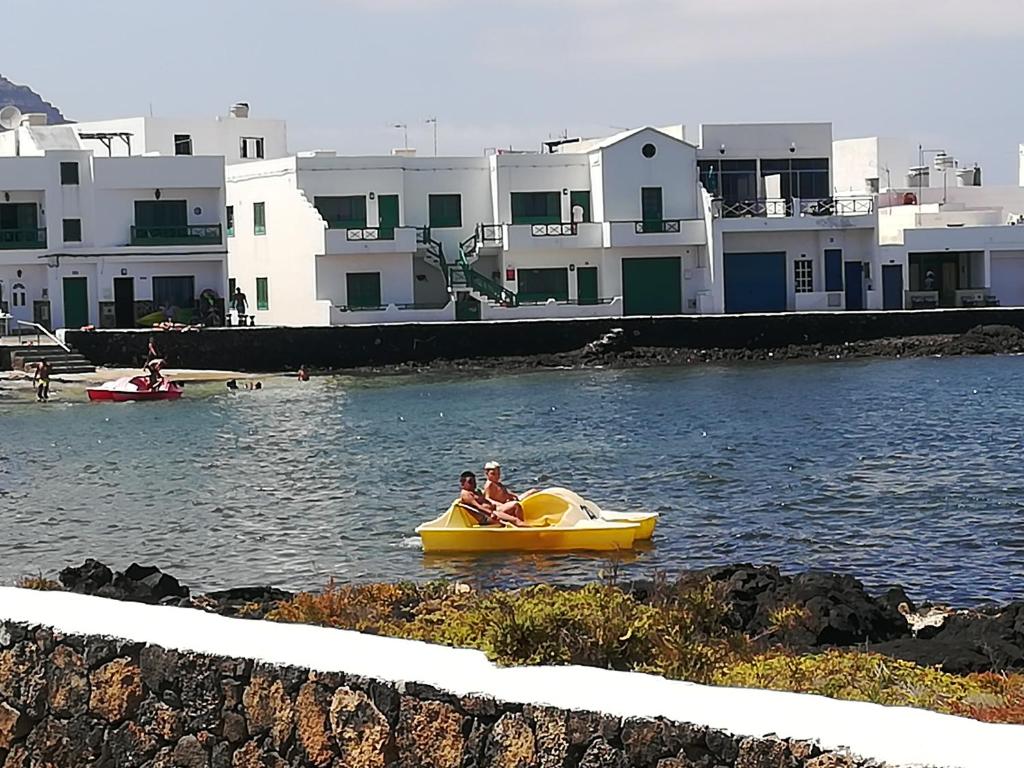 two people riding on a yellow boat in the water at Brisamarina de Órzola in Orzola