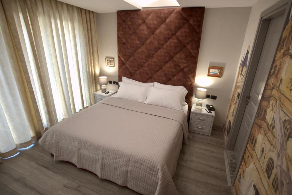 地拉那Vila Shard Boutique Hotel的一间带一张大床和两个床头柜的卧室