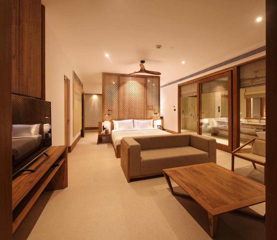 a hotel room with a bed and a couch at Riff Hikkaduwa in Hikkaduwa