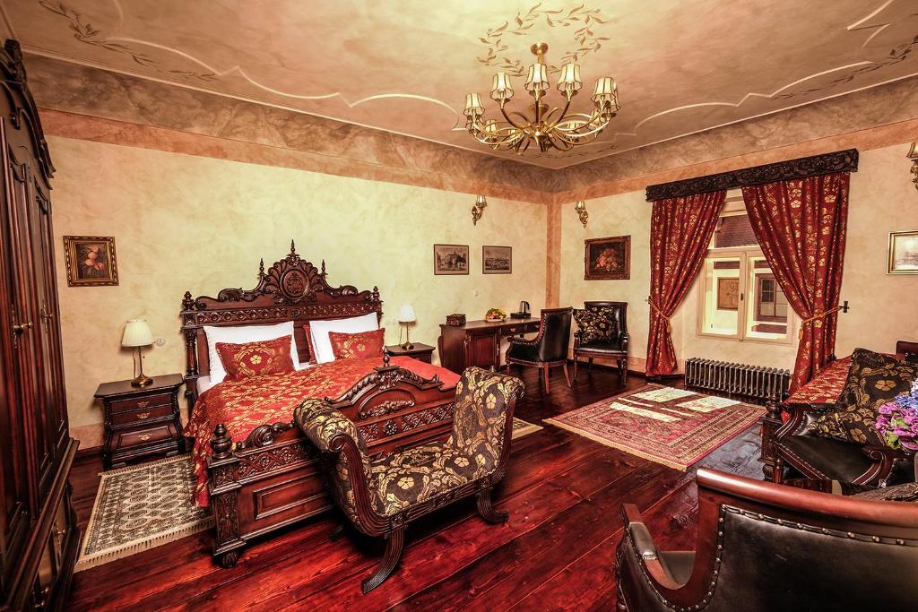 捷克克魯姆洛夫的住宿－Hotel Ebersbach，一间卧室配有一张床、椅子和吊灯