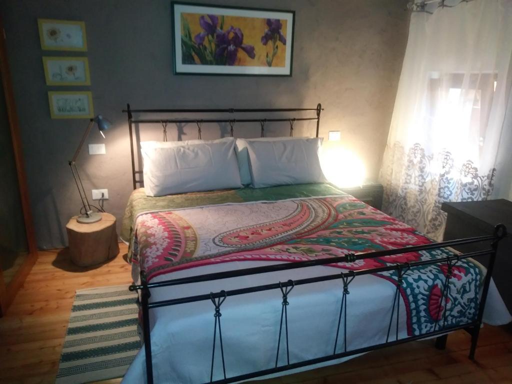 um quarto com uma cama com uma moldura em ferro forjado em Poggio del Sole em Bassano del Grappa