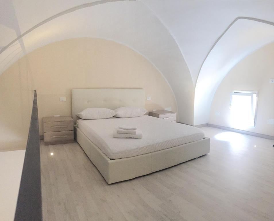 Biała sypialnia z łóżkiem i łukowym sufitem w obiekcie B&B MARIO PAGANO w mieście Brindisi