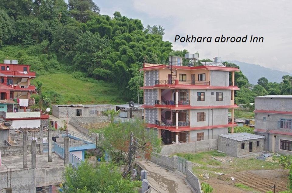 eine Gruppe von Gebäuden auf einem Hügel mit Bäumen in der Unterkunft Pokhara Abroad Inn in Pokhara