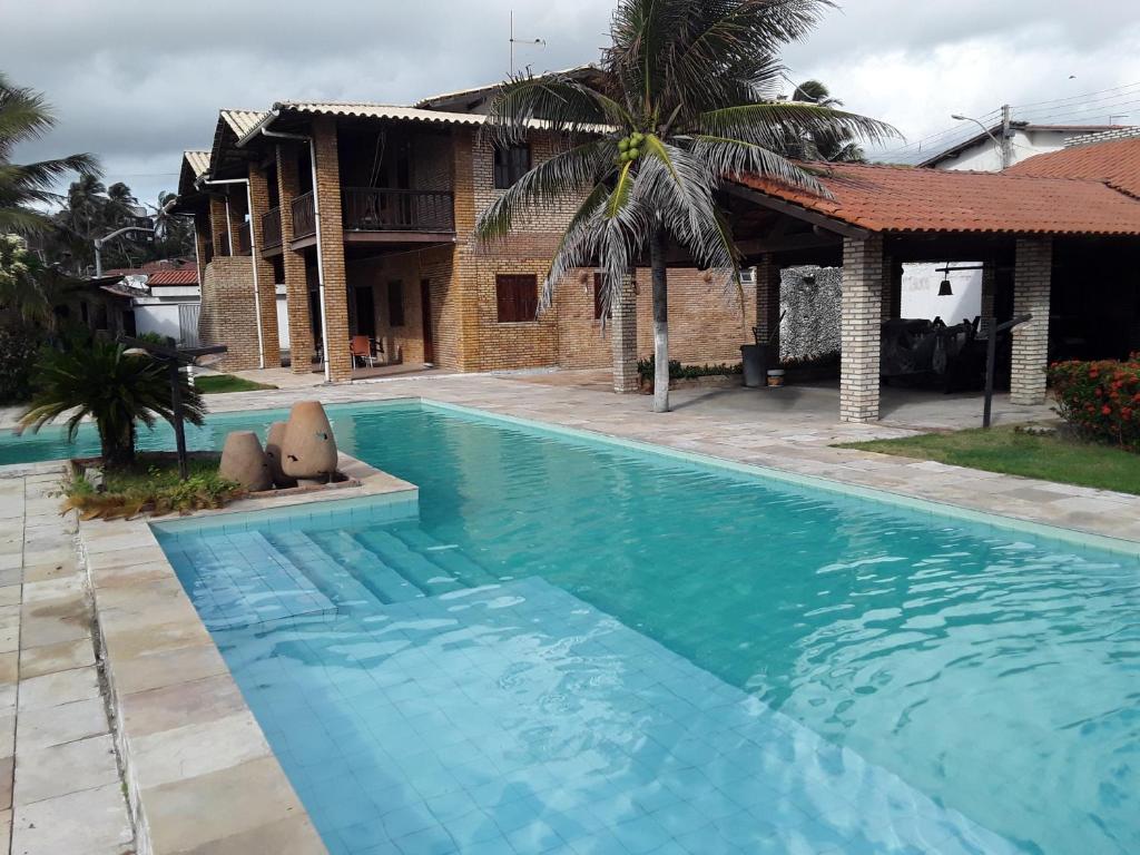a large swimming pool in front of a house at Villa Orazio Prainha in Prainha