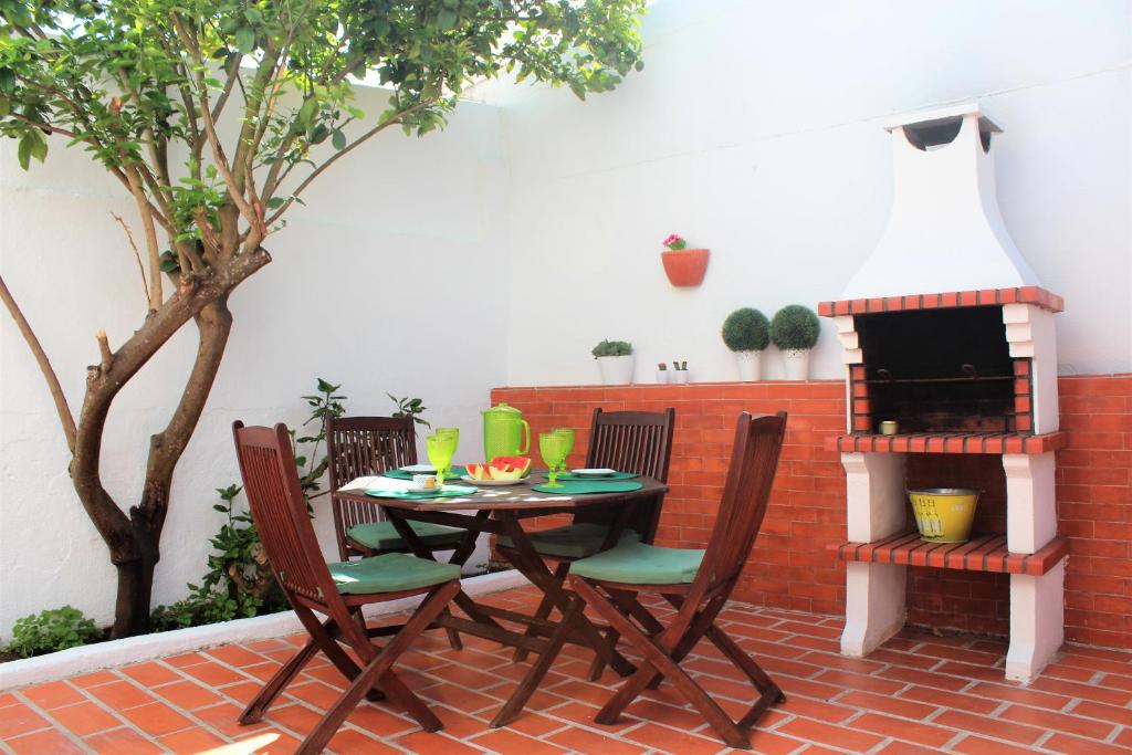 un patio con tavolo, sedie e casetta per uccelli. di Brito's House a Alcabideche