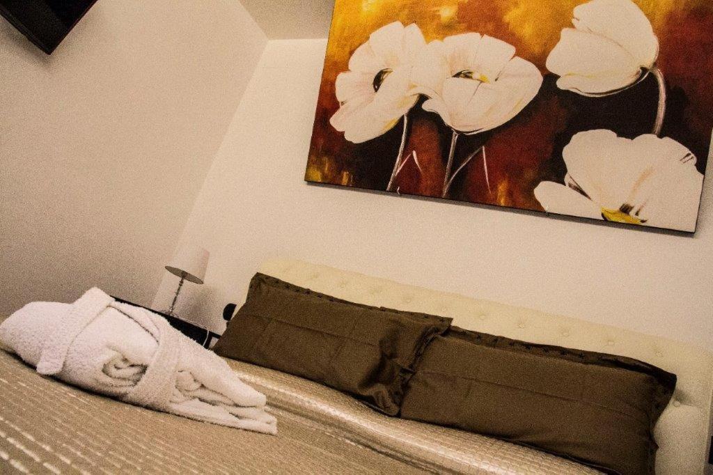 Schlafzimmer mit einem Bett mit Wandgemälde in der Unterkunft Little House in Modugno