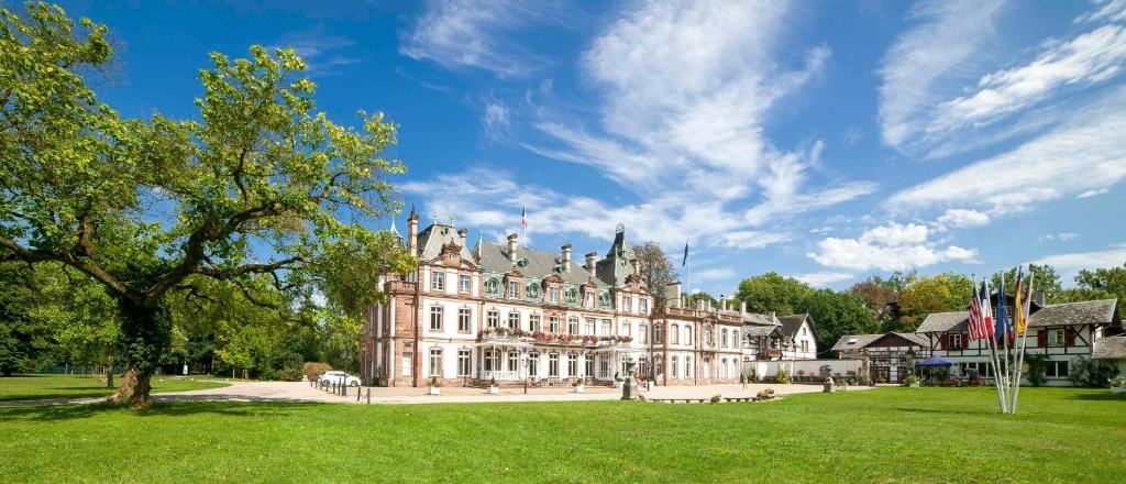 un grand bâtiment avec une pelouse verte devant lui dans l'établissement Château de Pourtalès, à Strasbourg