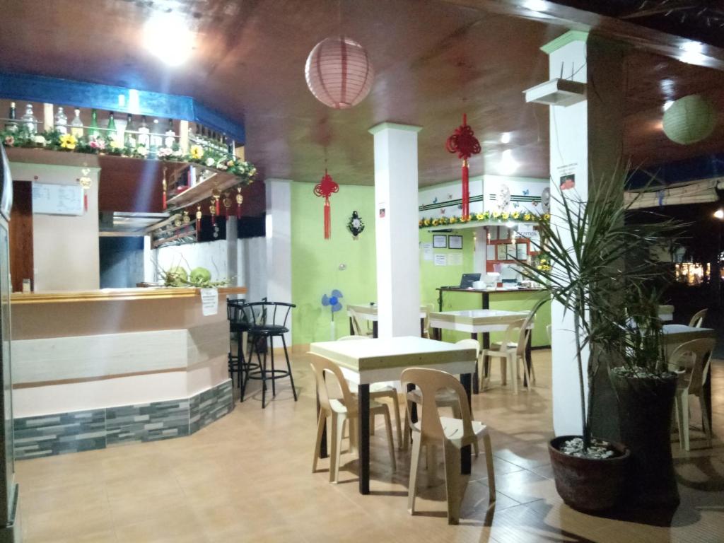 un ristorante con tavoli e sedie e un bar di Alona KatChaJo Inn a Panglao