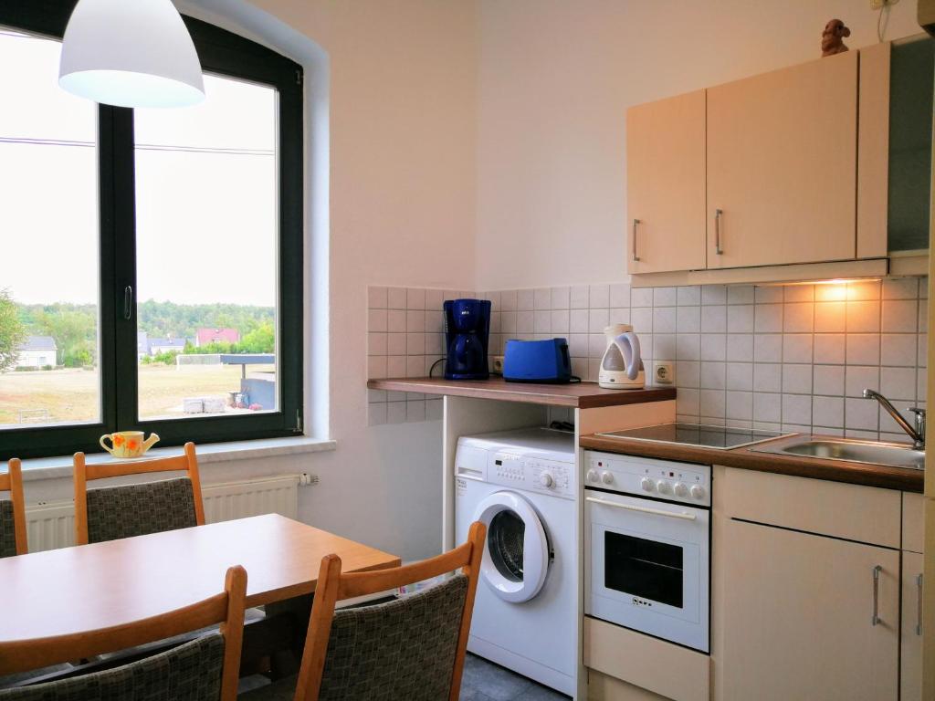 eine Küche mit einem Tisch, einer Spüle und einem Geschirrspüler in der Unterkunft Gäste und Ferienwohnung Gläser Zwickau in Zwickau