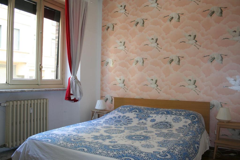トリノにあるAppartamento Conte Rossoの花柄の壁紙を用いたベッドルーム1室