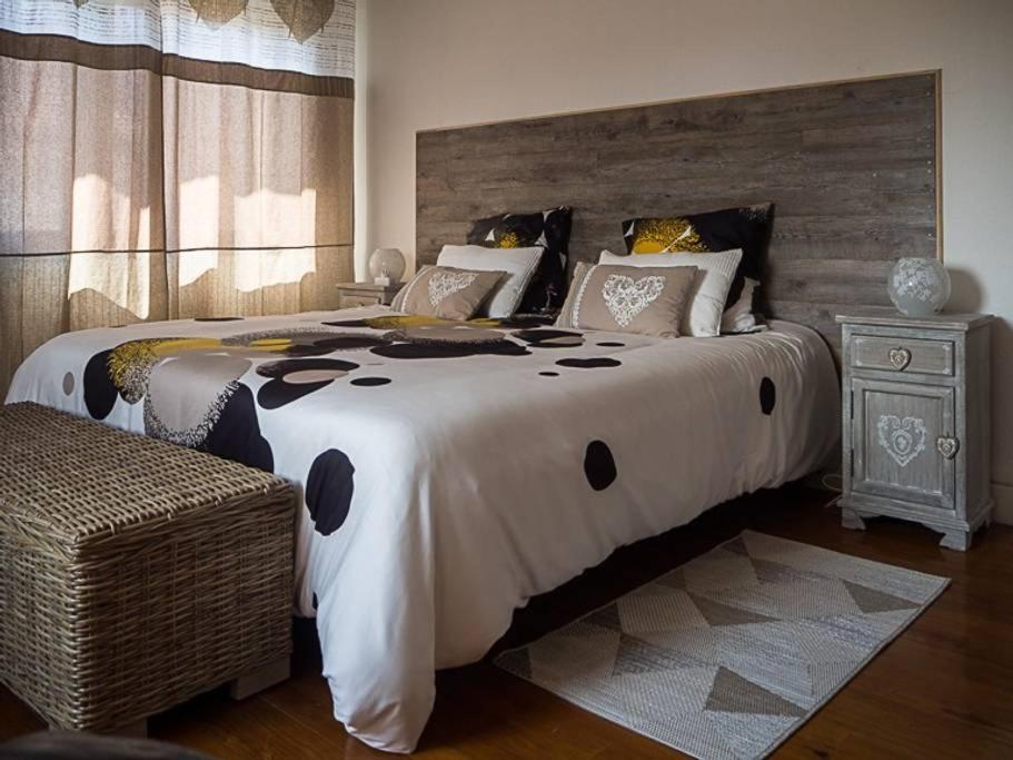 a bedroom with a large bed with a wooden headboard at Les abysses in Richwiller